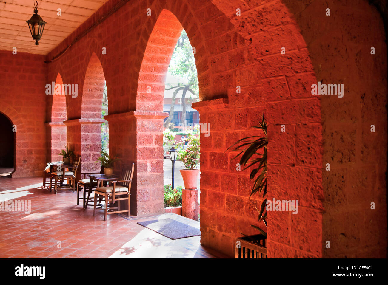 Paesaggio dettagli architettonici di archi a tutto sesto che conduce ai giardini maturi da un patio Foto Stock