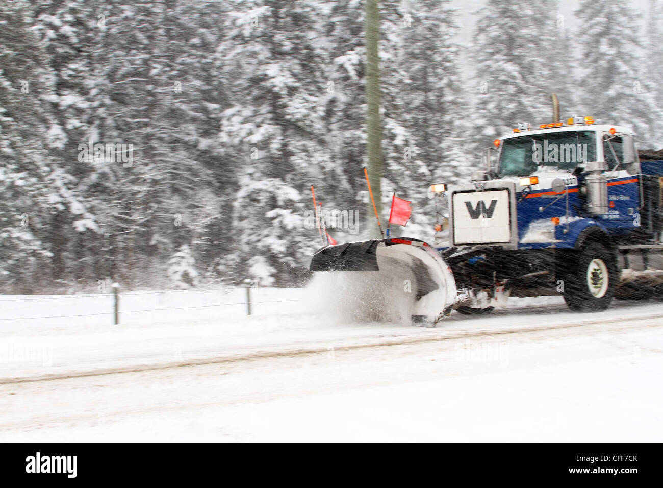 I lavori di manutenzione stradale spazzaneve la cancellazione del veicolo fuori la neve da una strada e la levigatura. Foto Stock