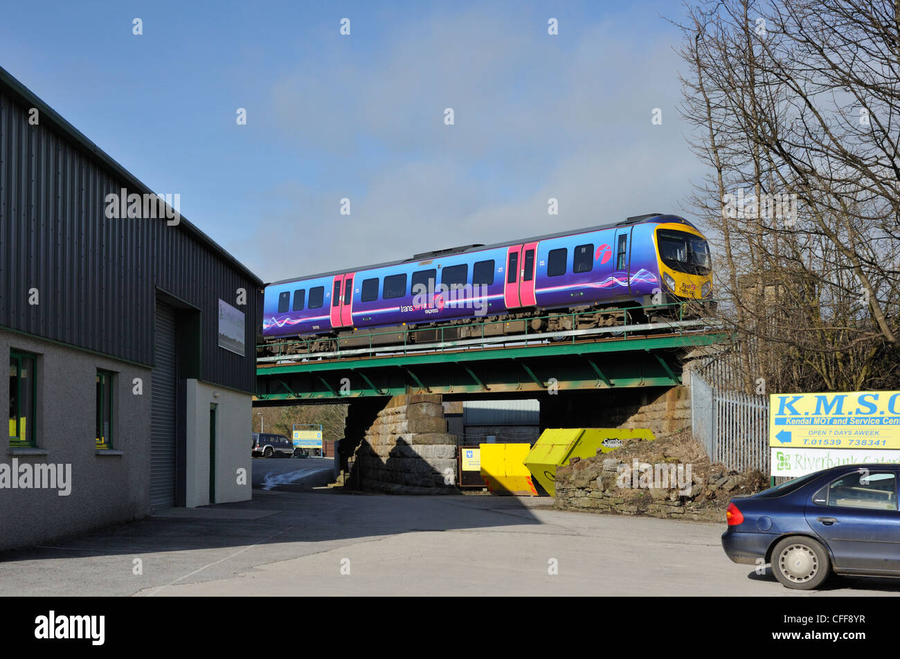 Primo Transpennine Express treno passa Dockray Industrial Estate, Kendal Cumbria, England, Regno Unito, Europa. Foto Stock
