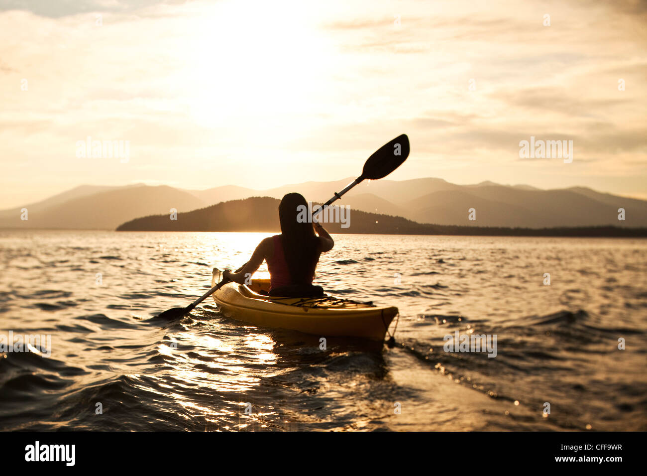 Un felice athletic donna kayak al tramonto su un lago in Idaho. Foto Stock