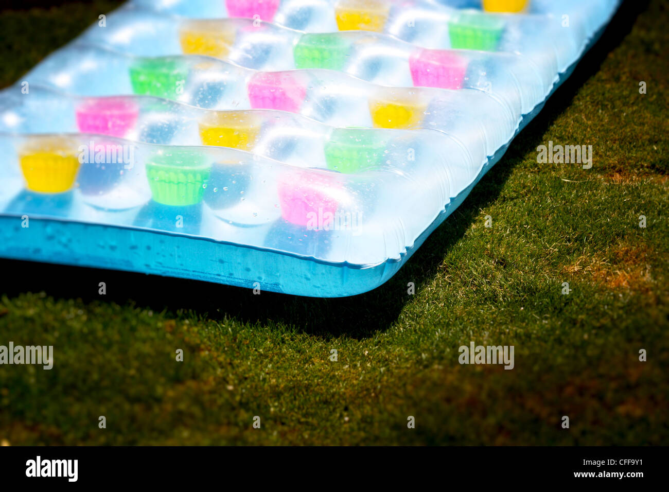 Sunny Lilo - un variopinto colpo di plastica fino a lilo sull'erba sotto il sole Foto Stock