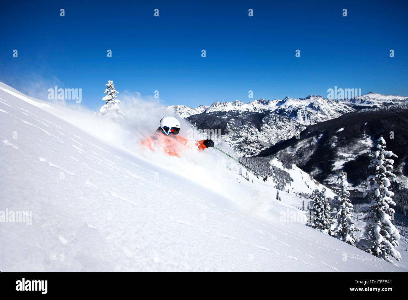Un athletic sciatore esegue il rip di polvere fresca si trasforma in una giornata di sole in Colorado. Foto Stock