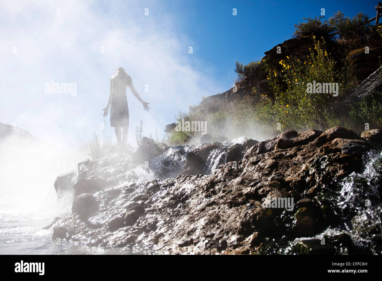 Un giovane uomo in piedi in una banca di vapore in un hotspring nel Montana. Foto Stock