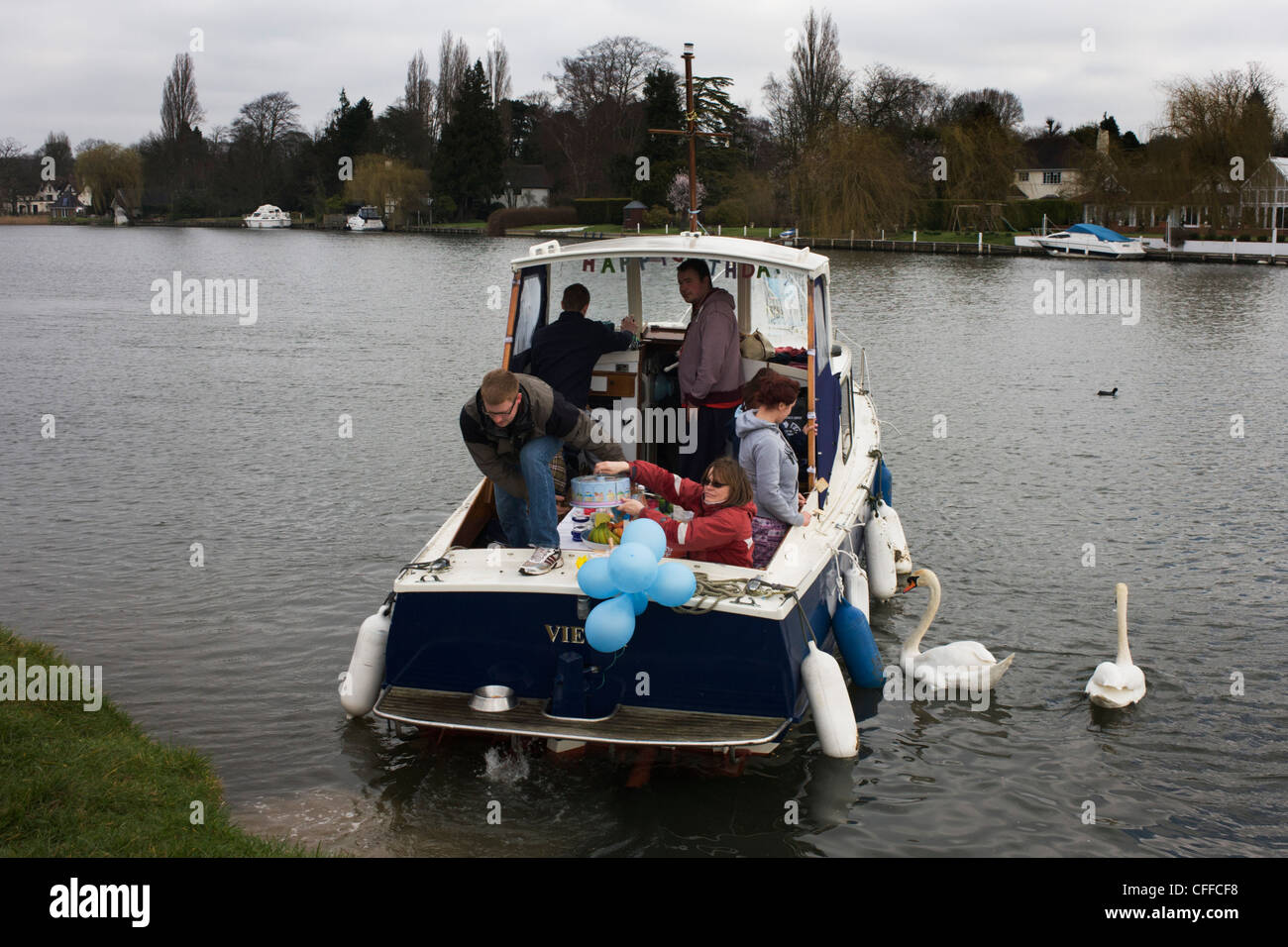 Amici per una giornata di gite in barca sul fiume Tamigi durante una festa di compleanno celebrazione presso Cookham, Berkshire. Foto Stock