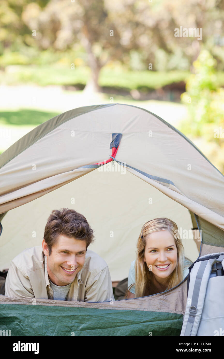 Sia l uomo e la donna sono sdraiato nella tenda con lo sportello aperto Foto Stock