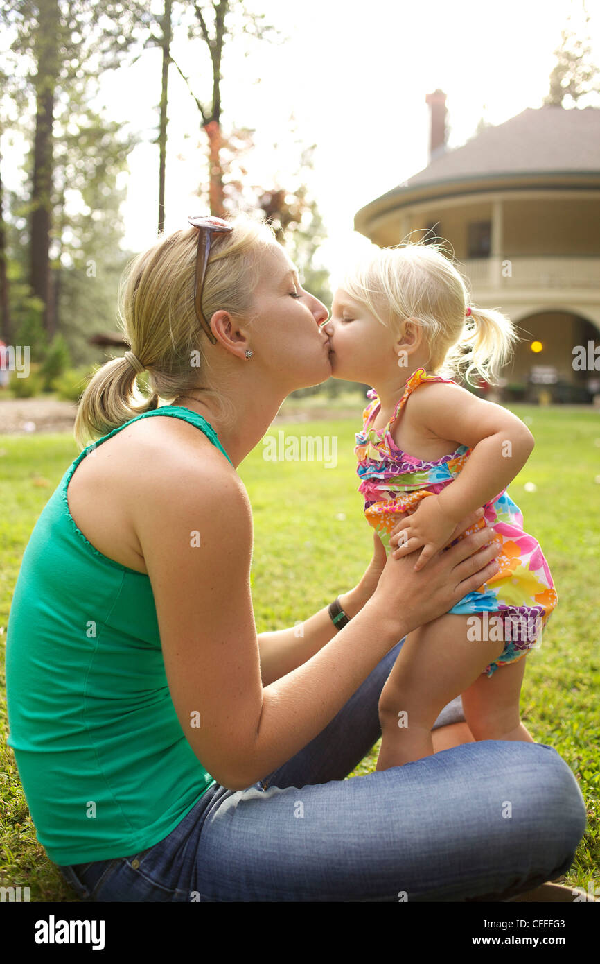 Una madre bacia la sua bambina. Foto Stock