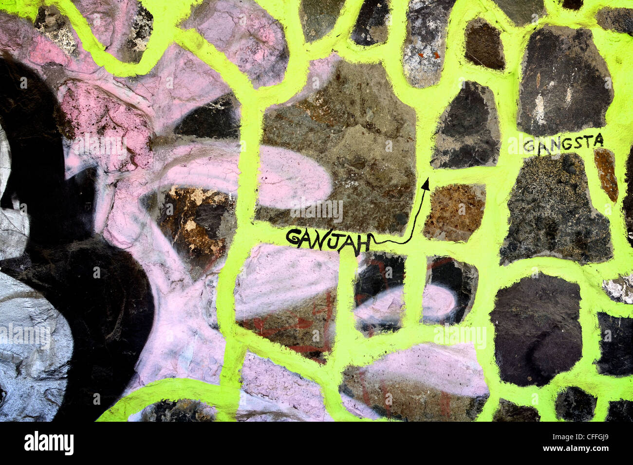 Costruzione di pareti di pietra cosparsa di vernice, vernice spray e pennarello graffiti. Graffiti tagging o Street art: Vandalismo pubblico o espressione artistica. Foto Stock