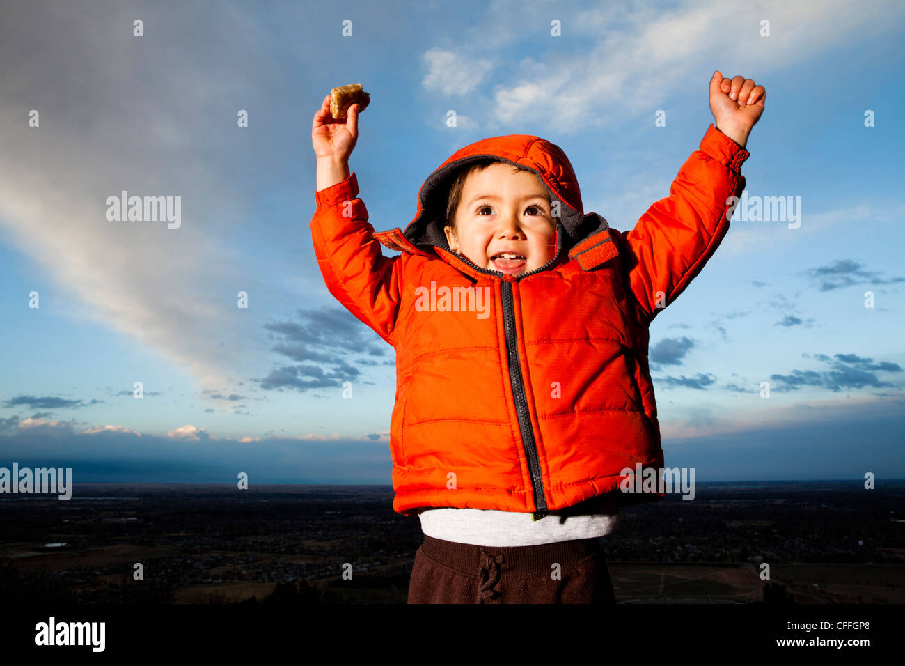 Un giovane ragazzo alza le mani in eccitazione all'aperto in Fort Collins, Colorado. Foto Stock