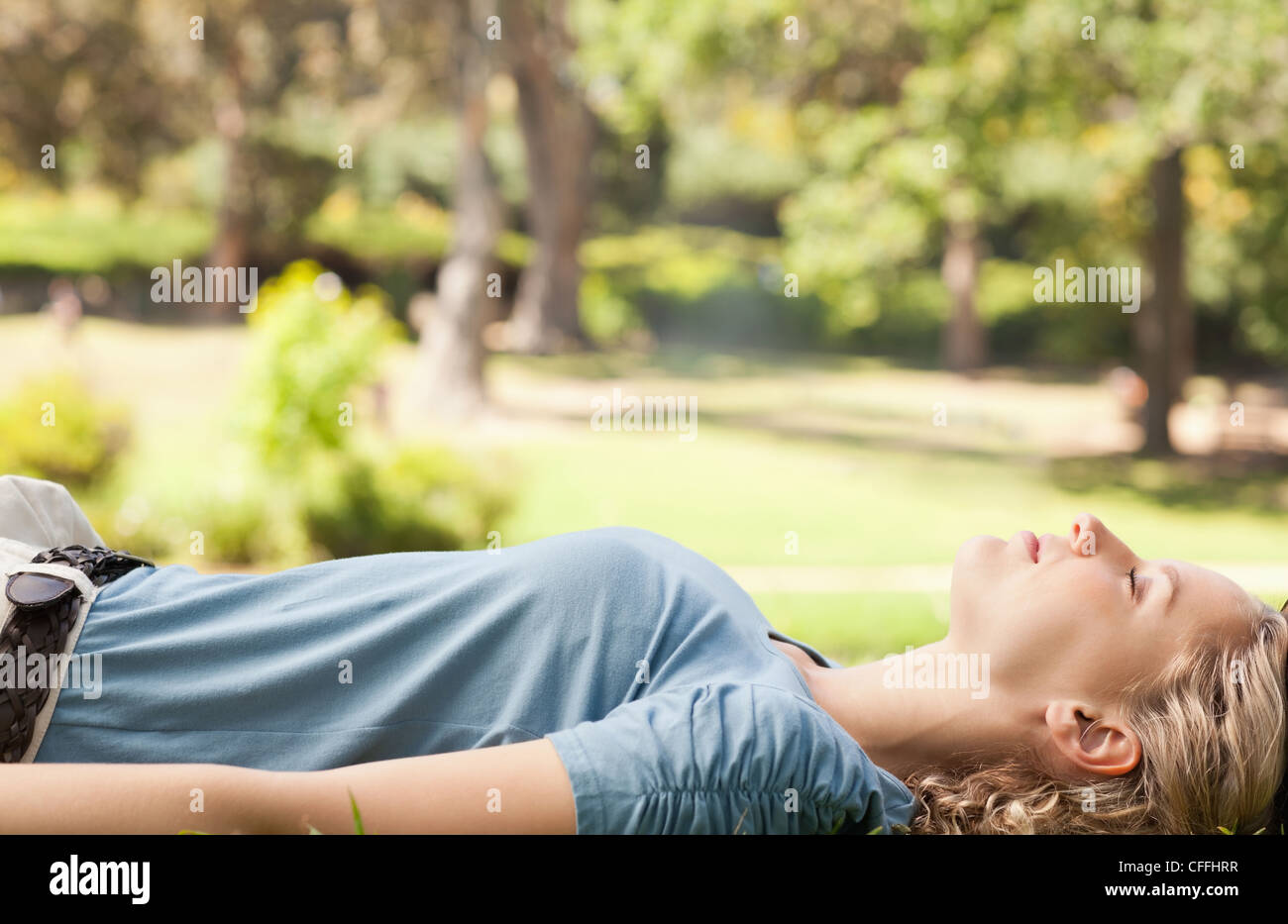 Vista laterale di una donna rilassarsi sul prato Foto Stock