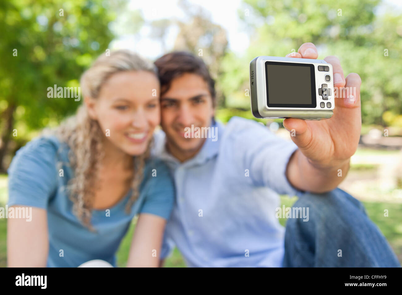 Fotocamera utilizzata per scattare una foto di un sorridente giovane Foto Stock