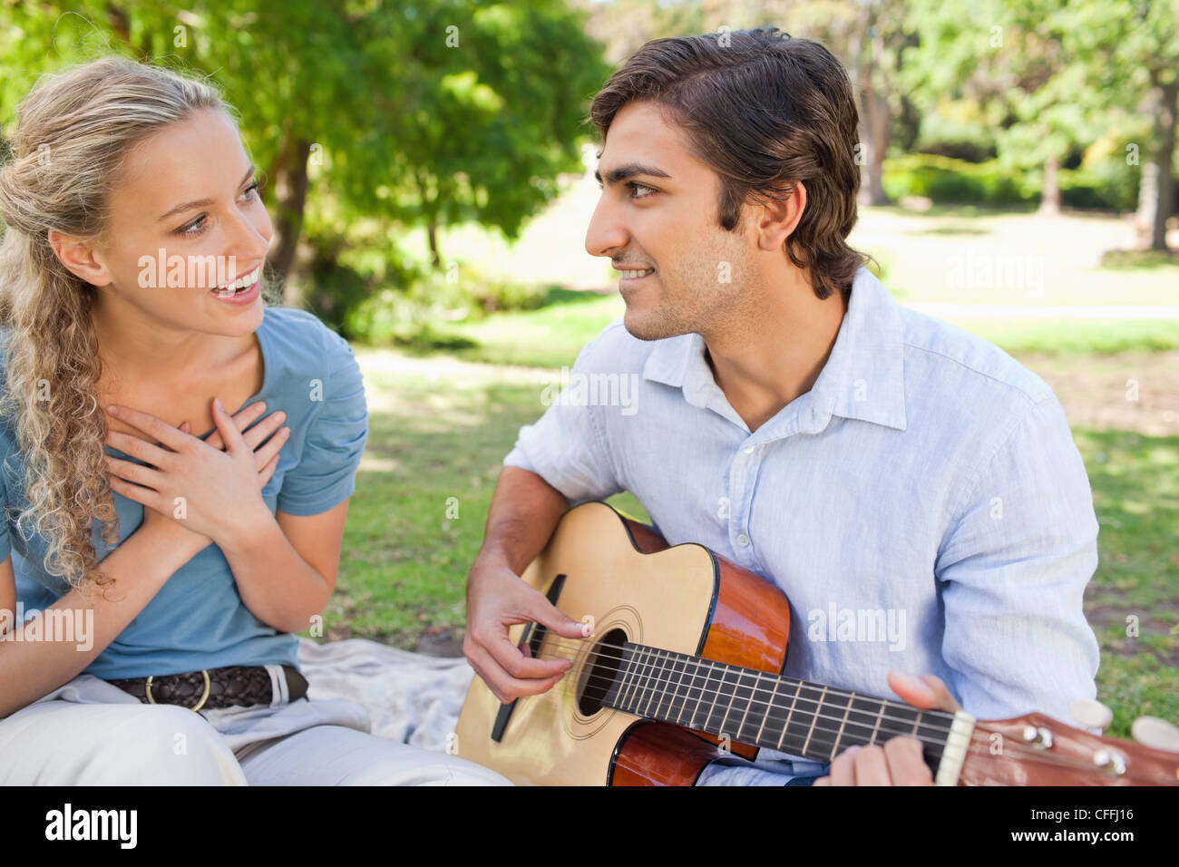 Maschio di suonare la chitarra per impressionare la sua ragazza Foto Stock