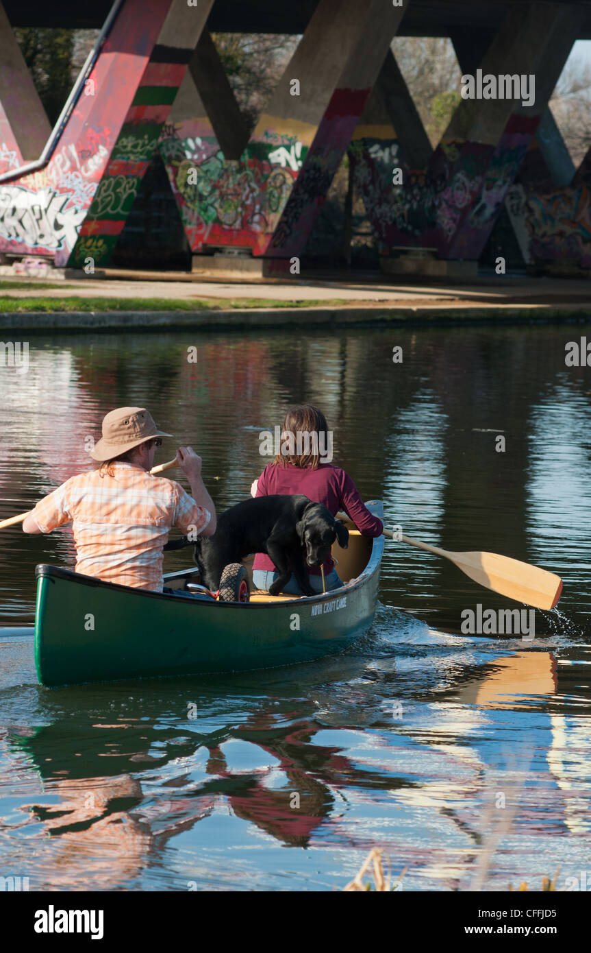 Due persone e un cane canoa sotto un ponte 14 lungo il fiume Cam. Cambridgeshire. In Inghilterra. Foto Stock