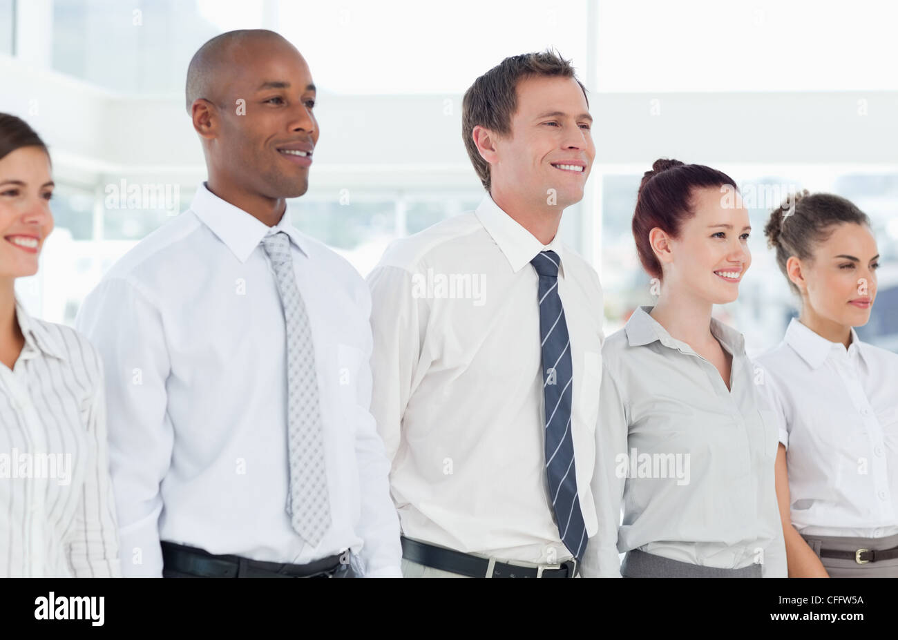 Sorridente team aziendale in piedi in una linea Foto Stock