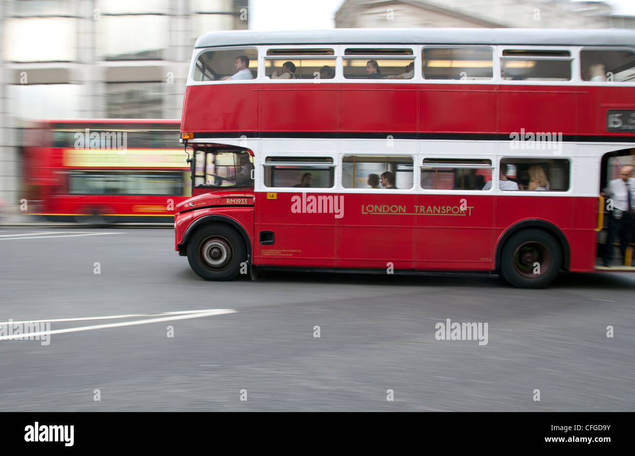 Rosso iconica London bus accelerando attraverso la città Foto Stock