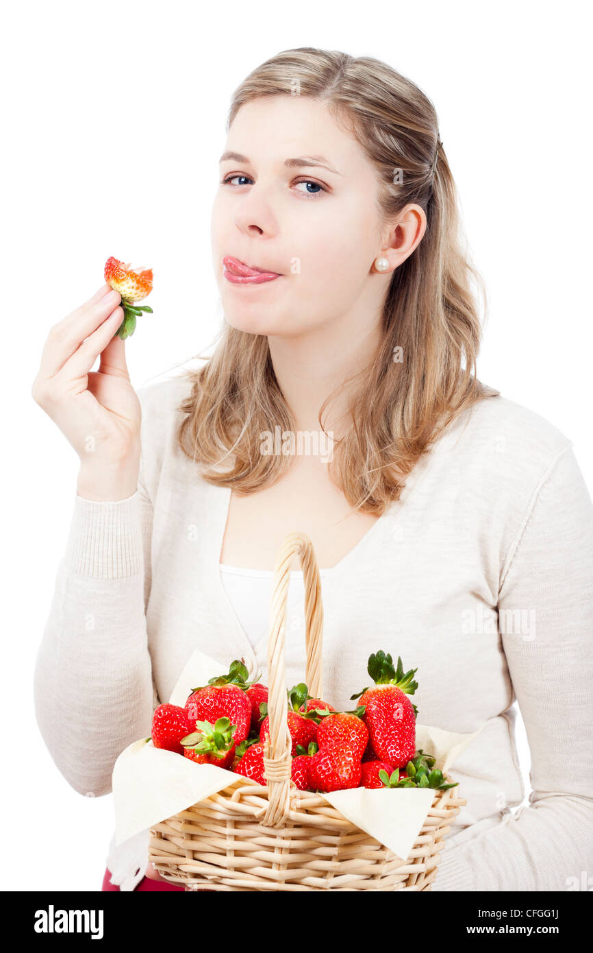 Bella giovane donna di mangiare fragole fresche, isolato su sfondo bianco. Foto Stock