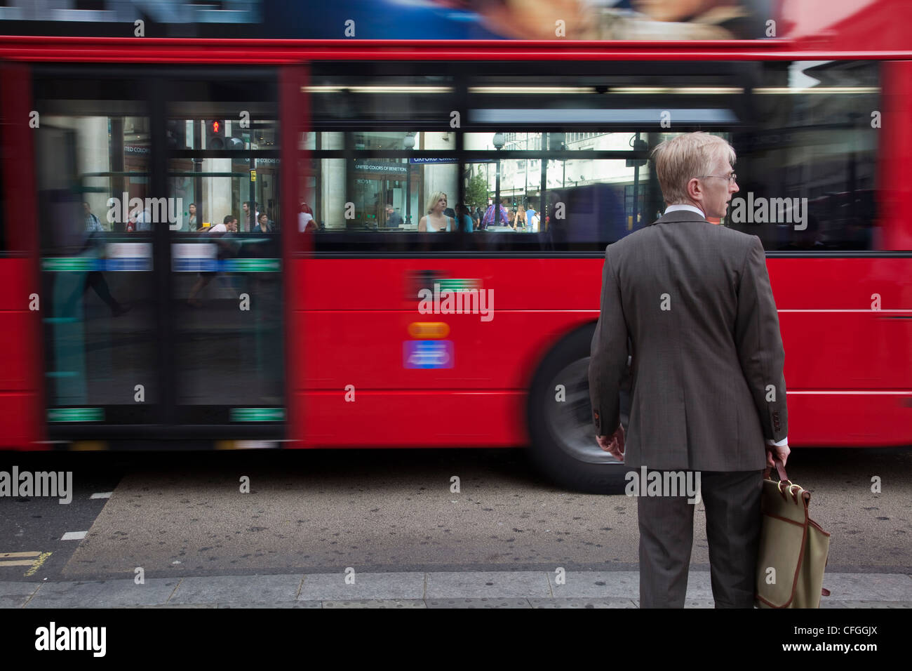 Rosso iconica London bus accelerando attraverso la città Foto Stock