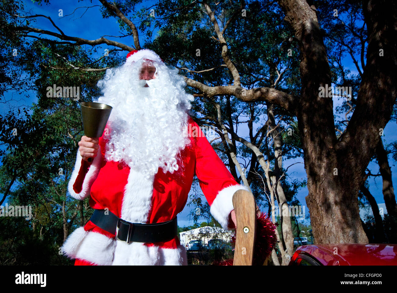 In un paese di campagna di Babbo Natale anelli il suo bell da una utility truck. Foto Stock
