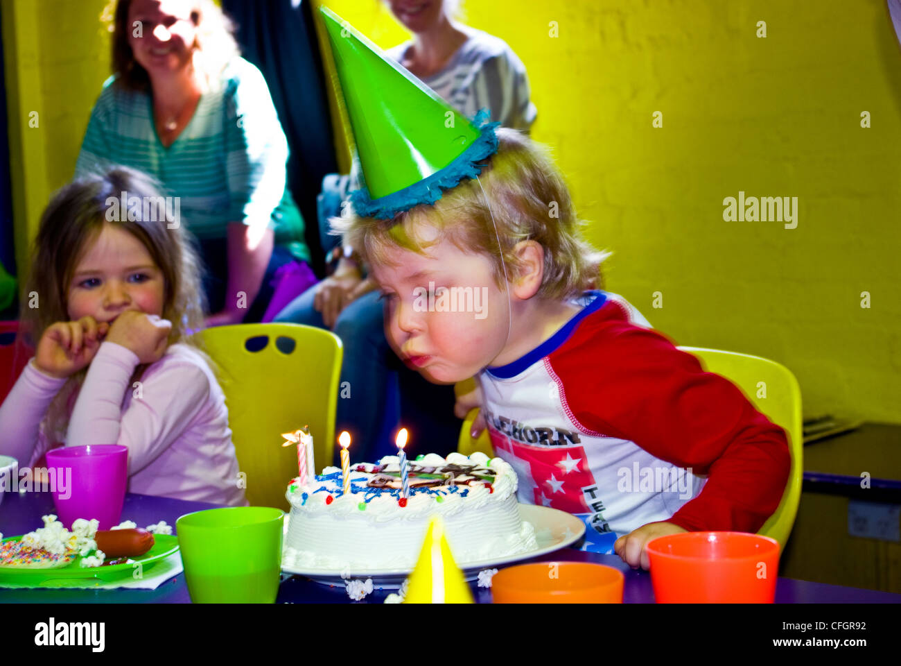 Un ragazzo si brucia candele sulla sua torta al suo quarto compleanno. Foto Stock