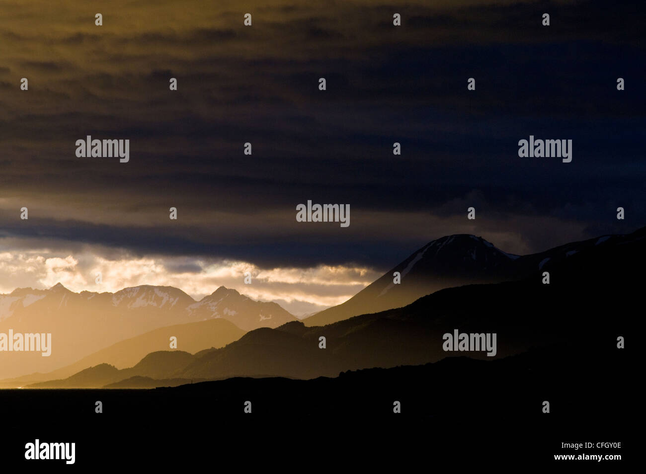 Raggi di sole pierce un buio minaccioso banca storm oltre le montagne delle Ande. Foto Stock