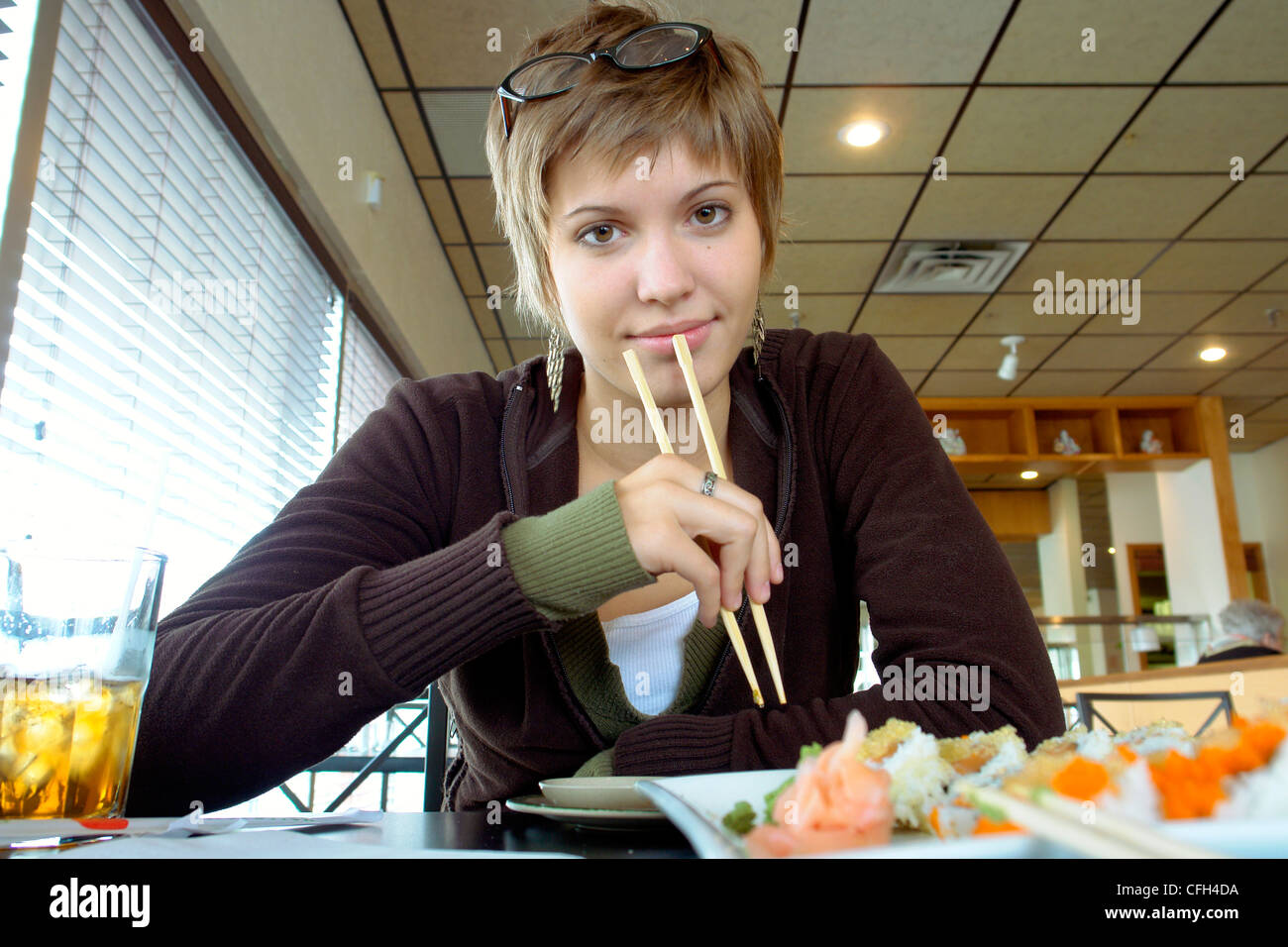 Giovane donna di mangiare sushi Foto Stock