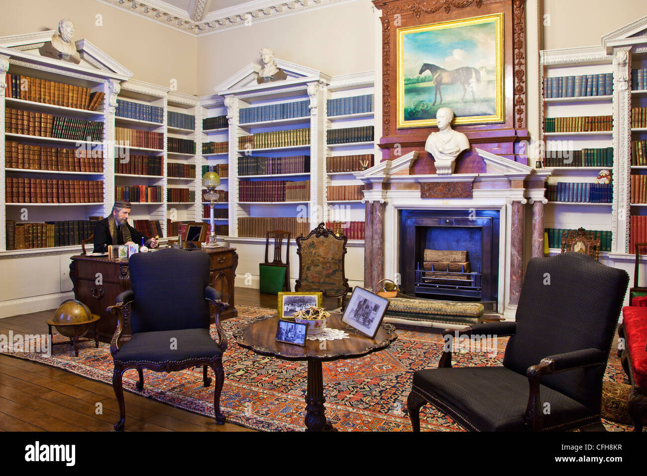 Lord Bolingbroke in libreria vittoriana in Lydiard House, Swindon, Wiltshire, Inghilterra. La riproduzione Stubbs oltre il camino. Foto Stock