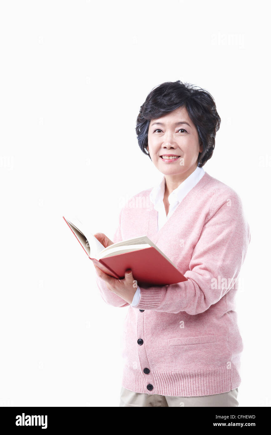 Una donna anziana con un libro Foto Stock