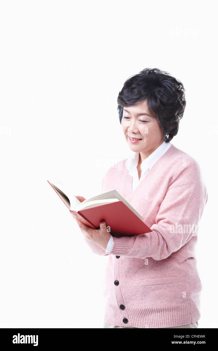 Una donna anziana la lettura di un libro Foto Stock