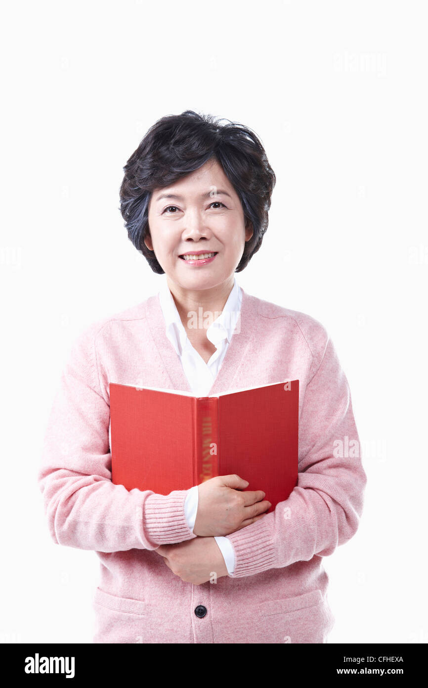 Una donna anziana con un libro Foto Stock