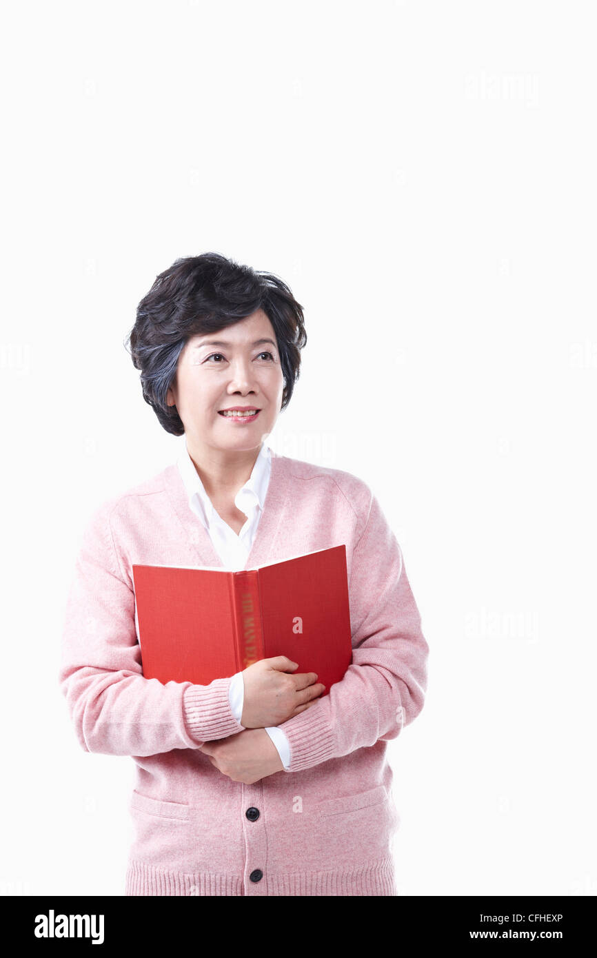 Una donna anziana con un libro Foto Stock