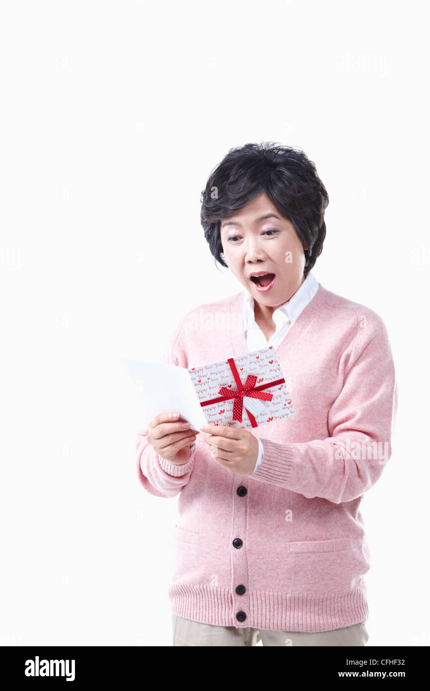 Una donna anziana sorprendente a una scheda Foto Stock