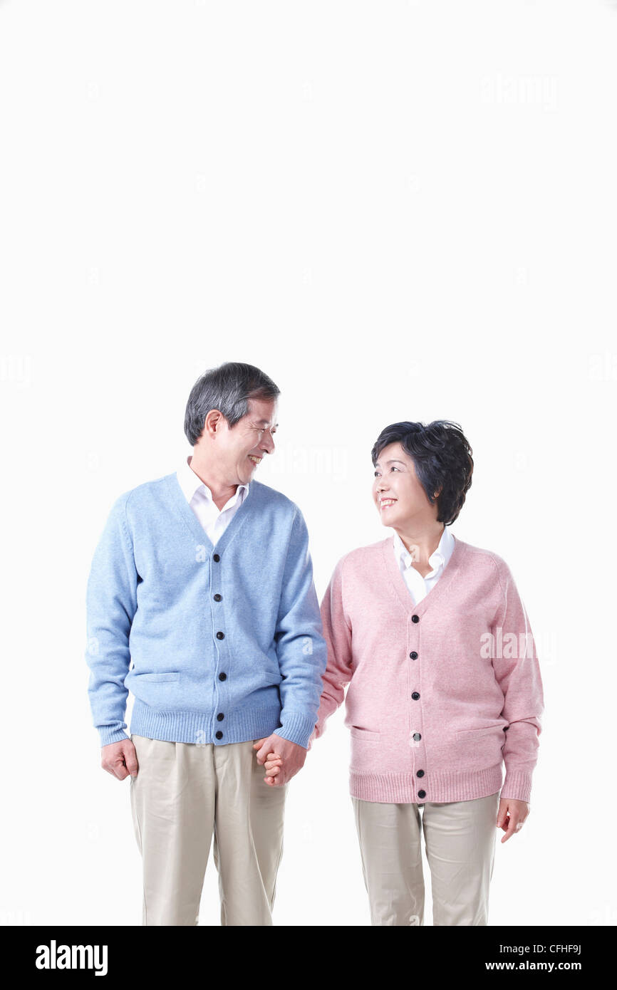 Un anziano uomo e donna che guarda ad ogni altro tenendo le mani insieme Foto Stock