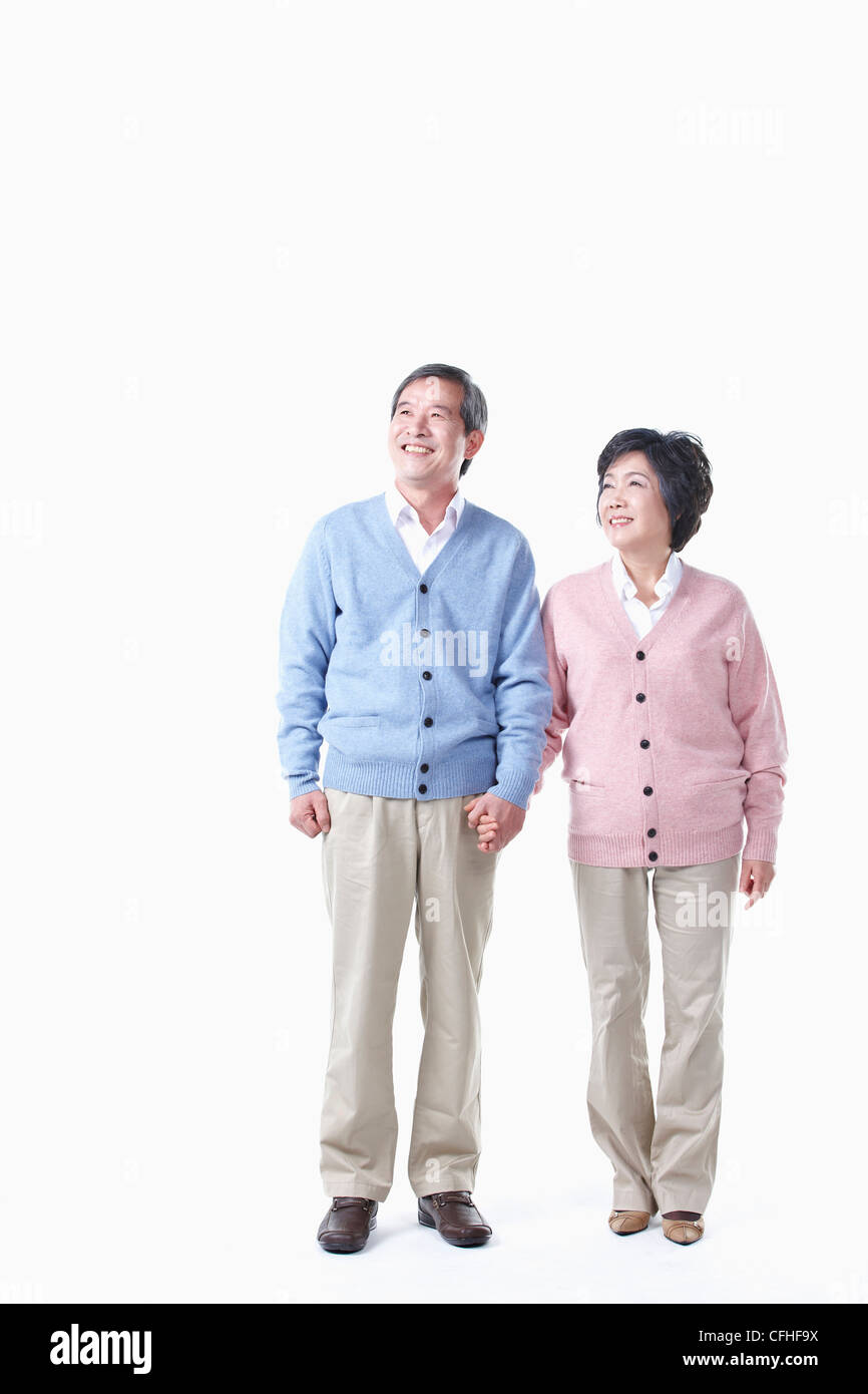 Un anziano uomo e donna guardando il cielo tenendo le mani insieme Foto Stock