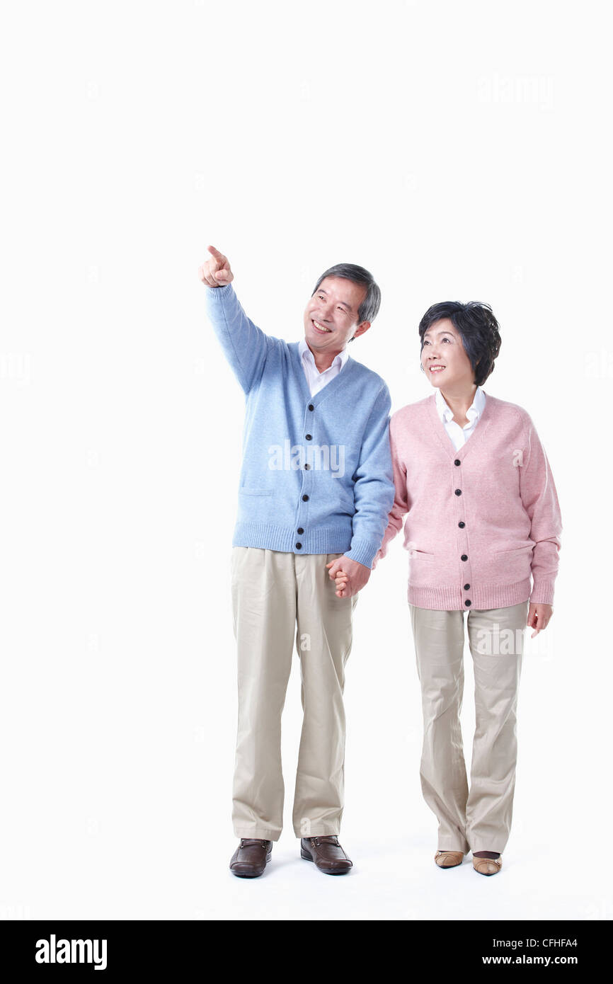 Un anziano uomo e donna guardando il cielo tenendo le mani insieme Foto Stock