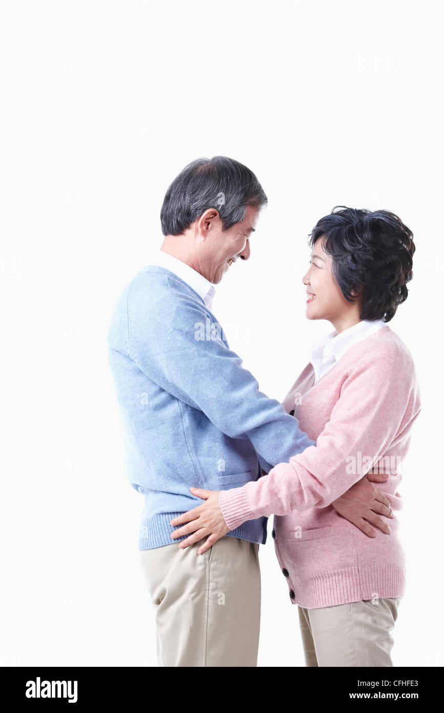 Un anziano uomo e donna avente bracci intorno a ciascun altro Foto Stock