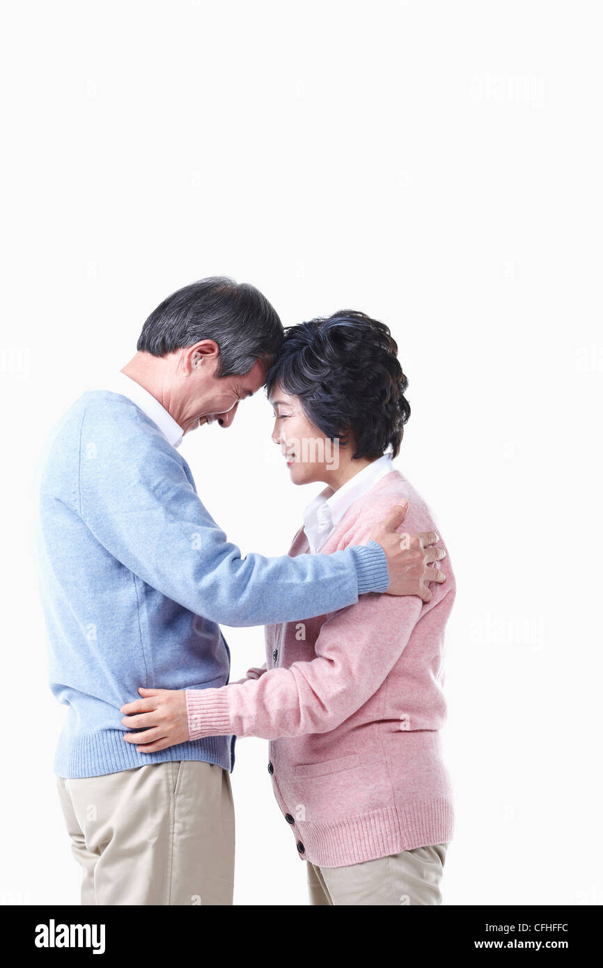 Un anziano uomo e donna avente bracci intorno a ciascun altro Foto Stock