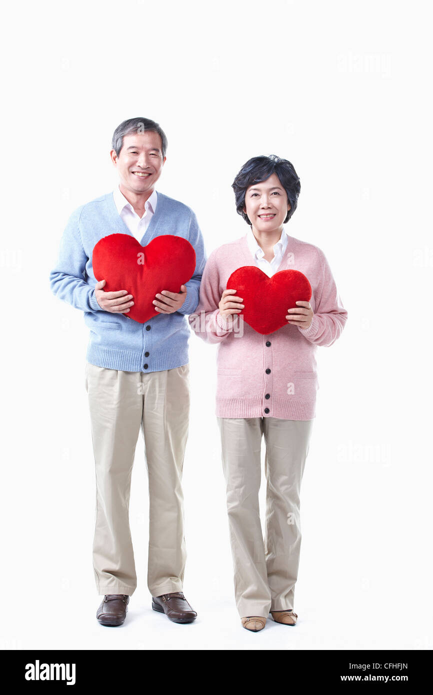Un anziano uomo e donna con il cuore rosso Foto Stock