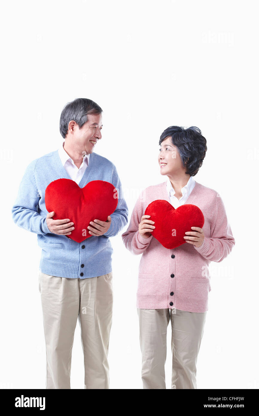 Un anziano uomo e donna con il cuore rosso Foto Stock