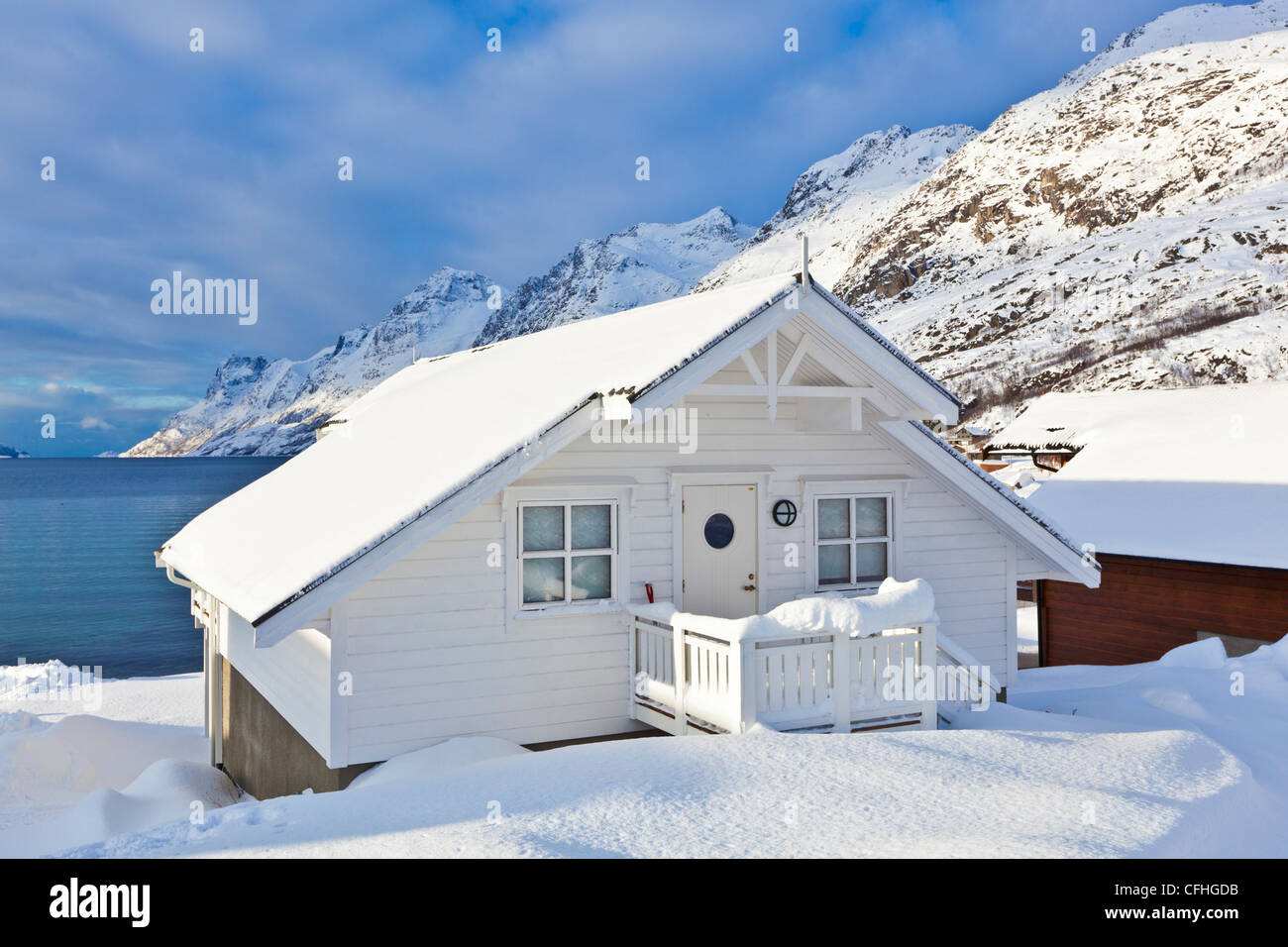 Coperta di neve chalet hutte nel fiordo norvegese villaggio di Ersfjord, isola Kvaloya,Troms, Norvegia, Europa Foto Stock