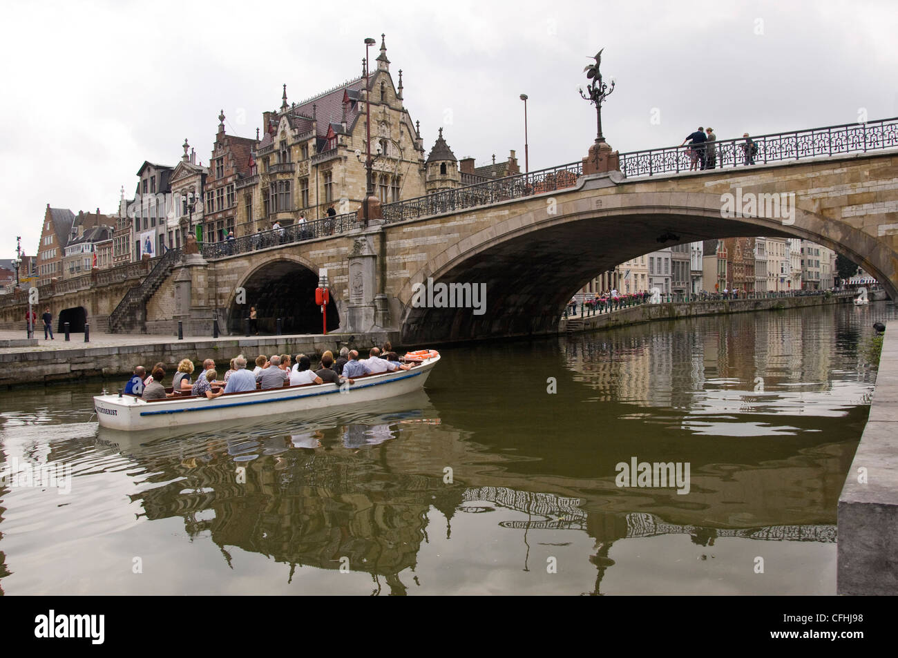 In orizzontale ampia angolazione di Sint Michielsbrug ponte che attraversa il fiume Leie con un gruppo di tour a bordo di una barca sotto a Gand, Belgio Foto Stock