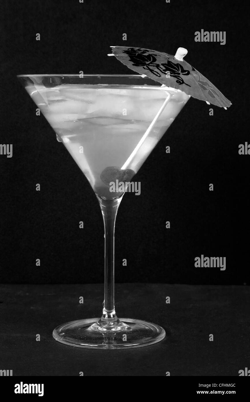 Bicchiere da cocktail con bevanda, parasol stick e ciliegia Foto Stock