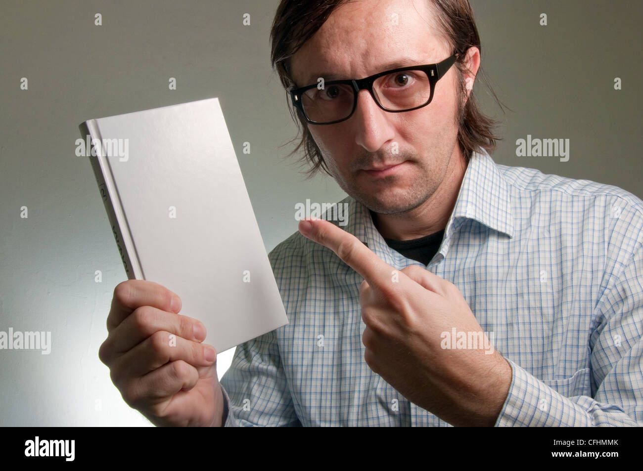 Nerd maschio in possesso di un libro con vuoto copre bianco, questa immagine è un concetto umoristico foto. Foto Stock