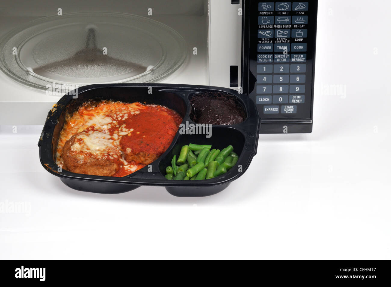 Carne di vitello cotto alla parmigiana readymeal tv la cena con fagiolini e  dessert brownie nella parte anteriore del forno a microonde con sportello  aperto USA Foto stock - Alamy