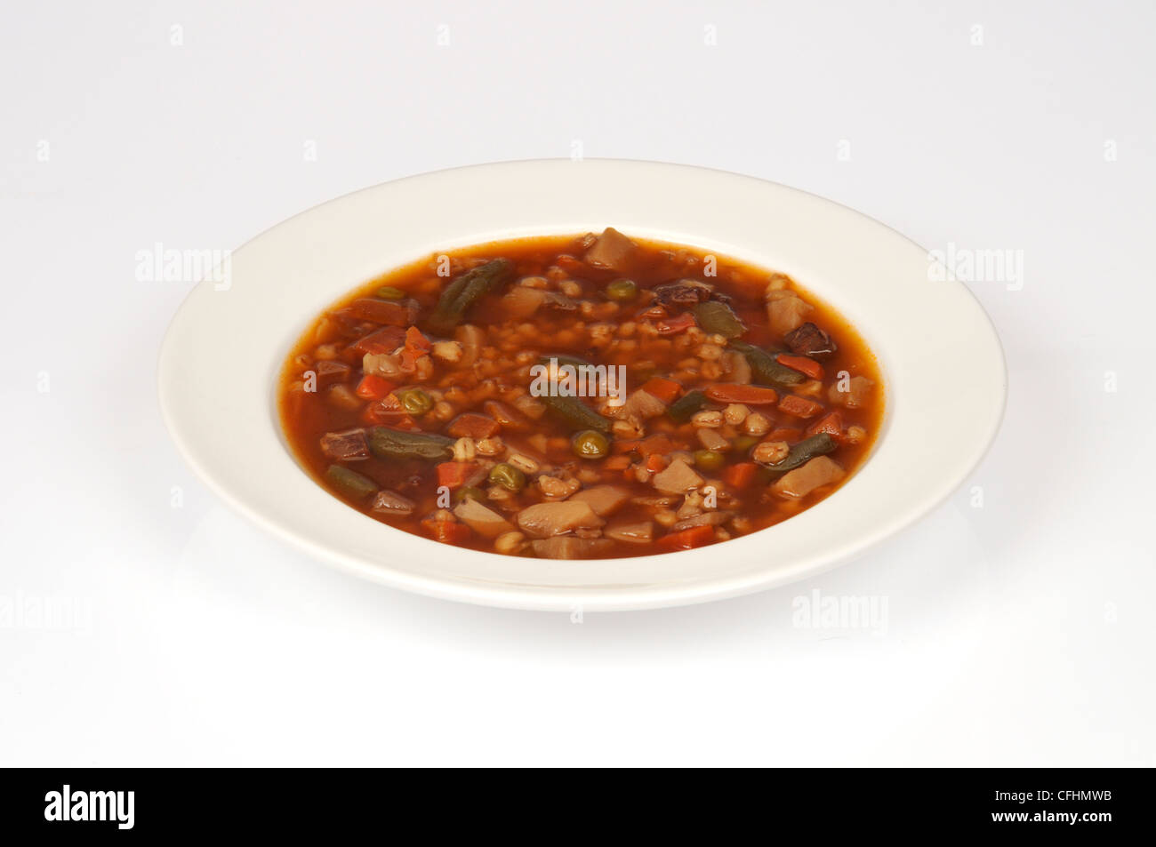 Un vegetale sostanziosa zuppa di manzo con carote, fagioli verdi di patate e carne di manzo in ciotola bianco su sfondo bianco isolato. Foto Stock