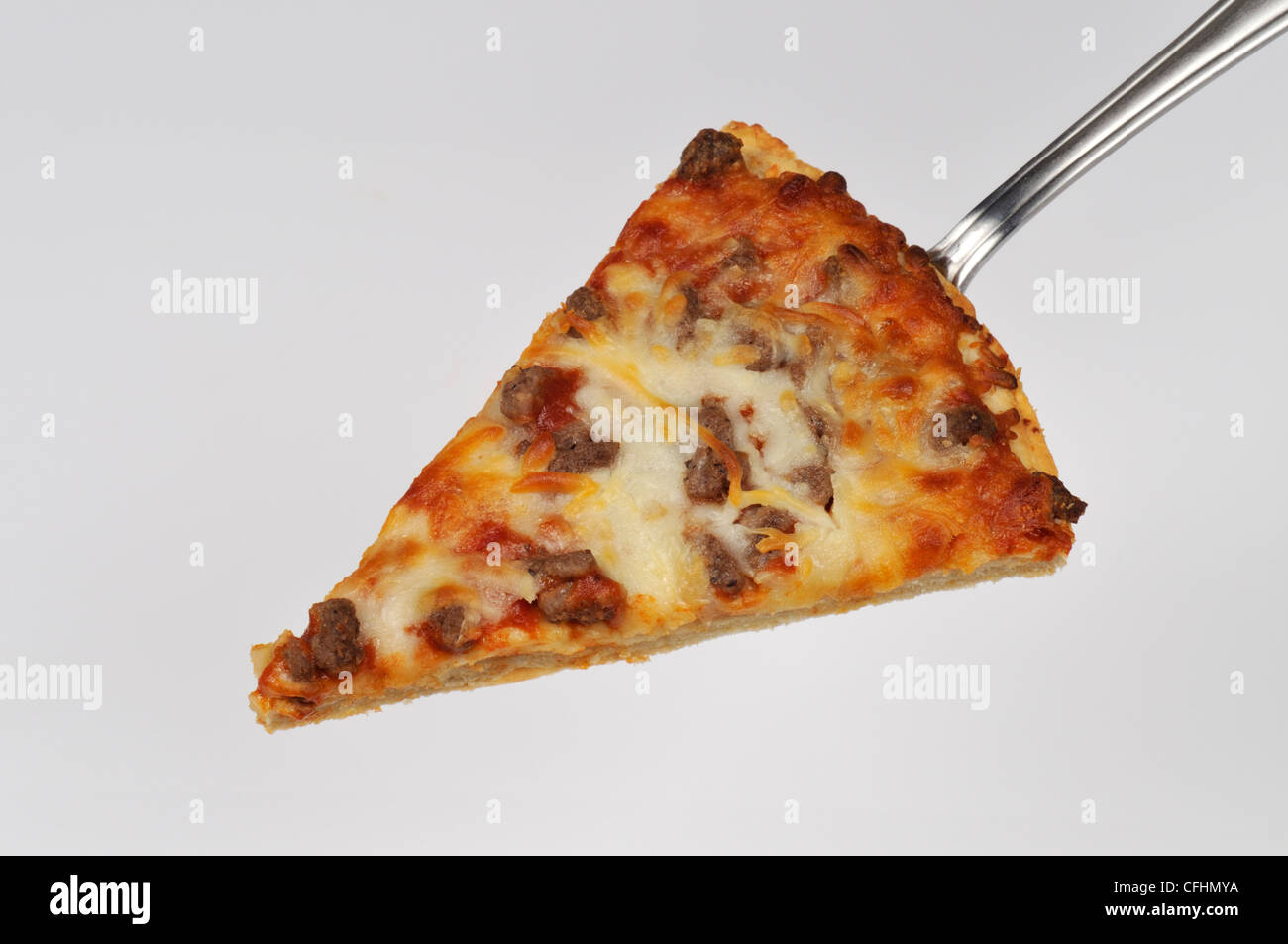 Trancio di pizza con formaggio e polpette con condimenti su una spatola closeup Foto Stock