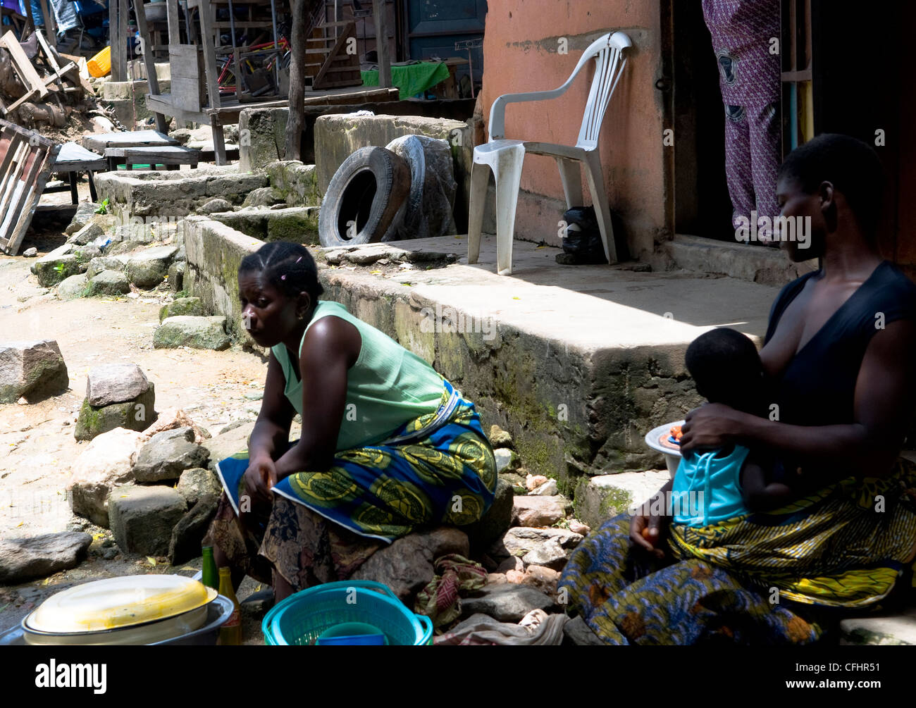 Allattamento al seno il suo bambino in un mercato locale nel nord del Togo. Foto Stock