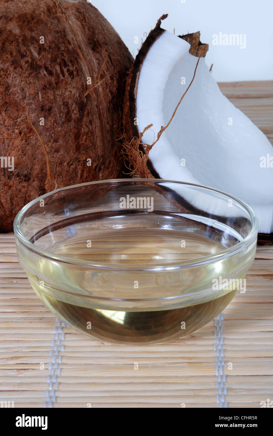 Olio di noce di cocco su un tappetino di bambù Foto Stock