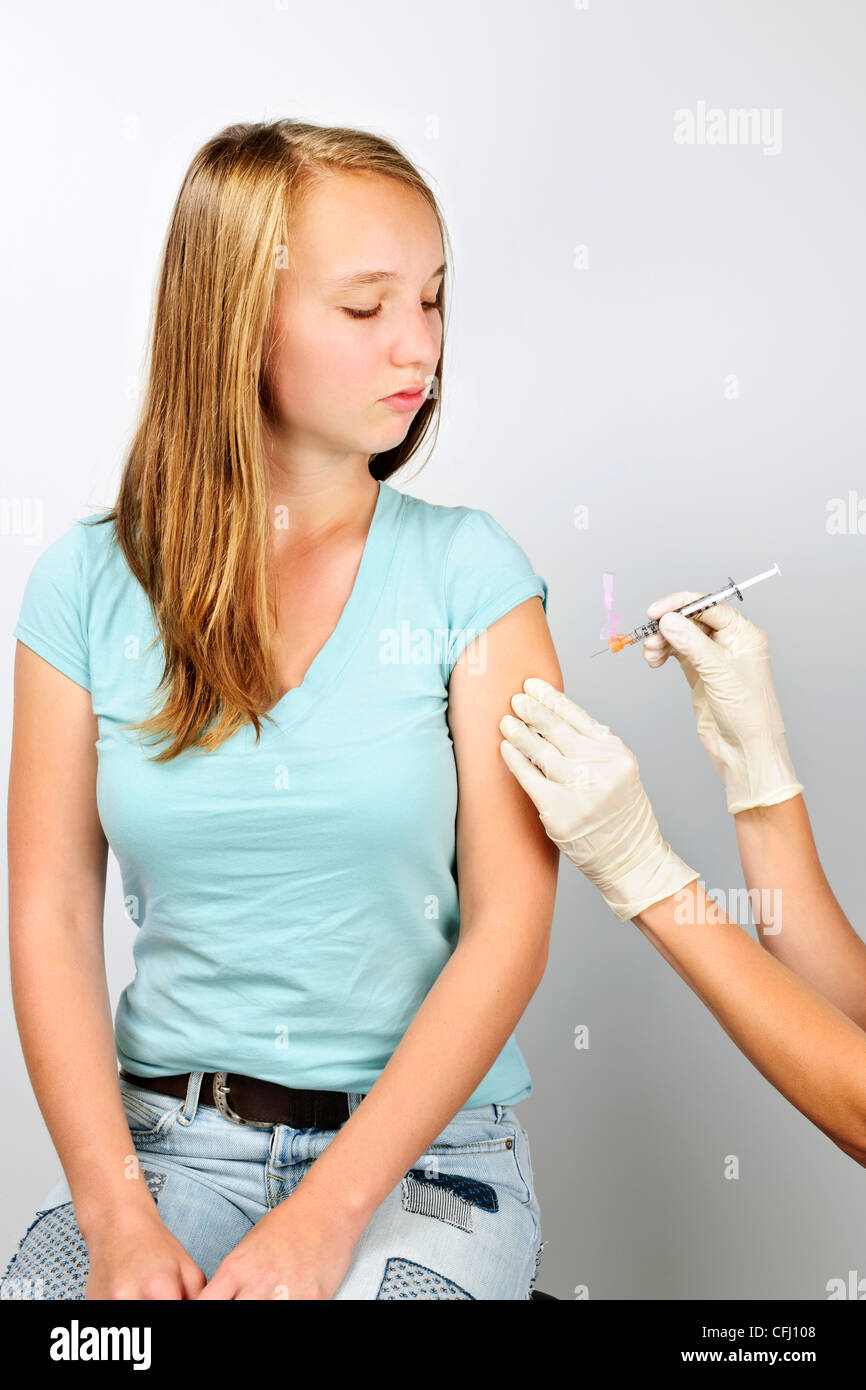 Ragazza adolescente getting vaccino antinfluenzale vaccinazione ad ago nel braccio Foto Stock