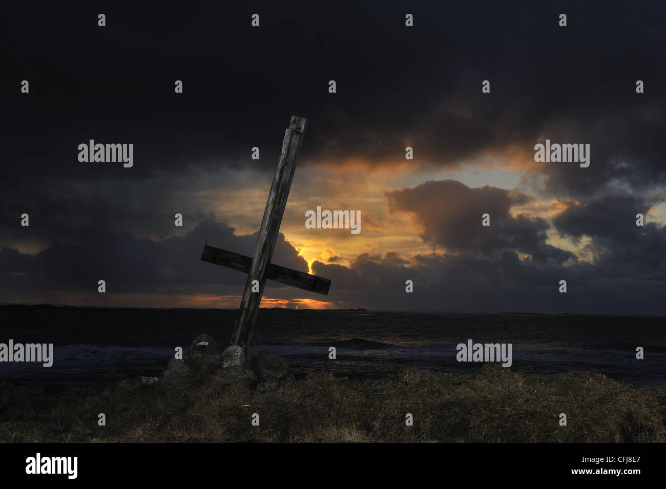 Croce di legno in silhouette al tramonto sulla costa occidentale della Norvegia Foto Stock