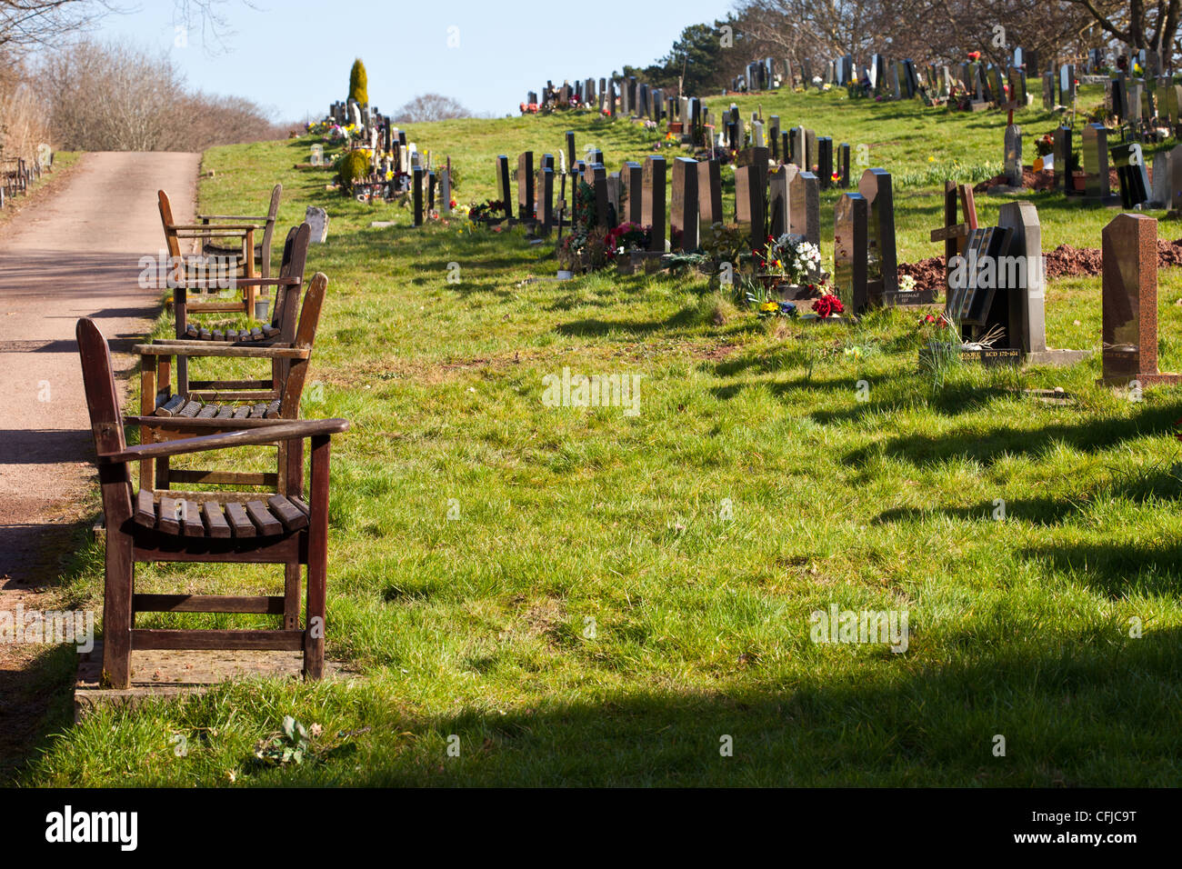 Panca per persone in lutto a sedersi al cimitero. Foto Stock