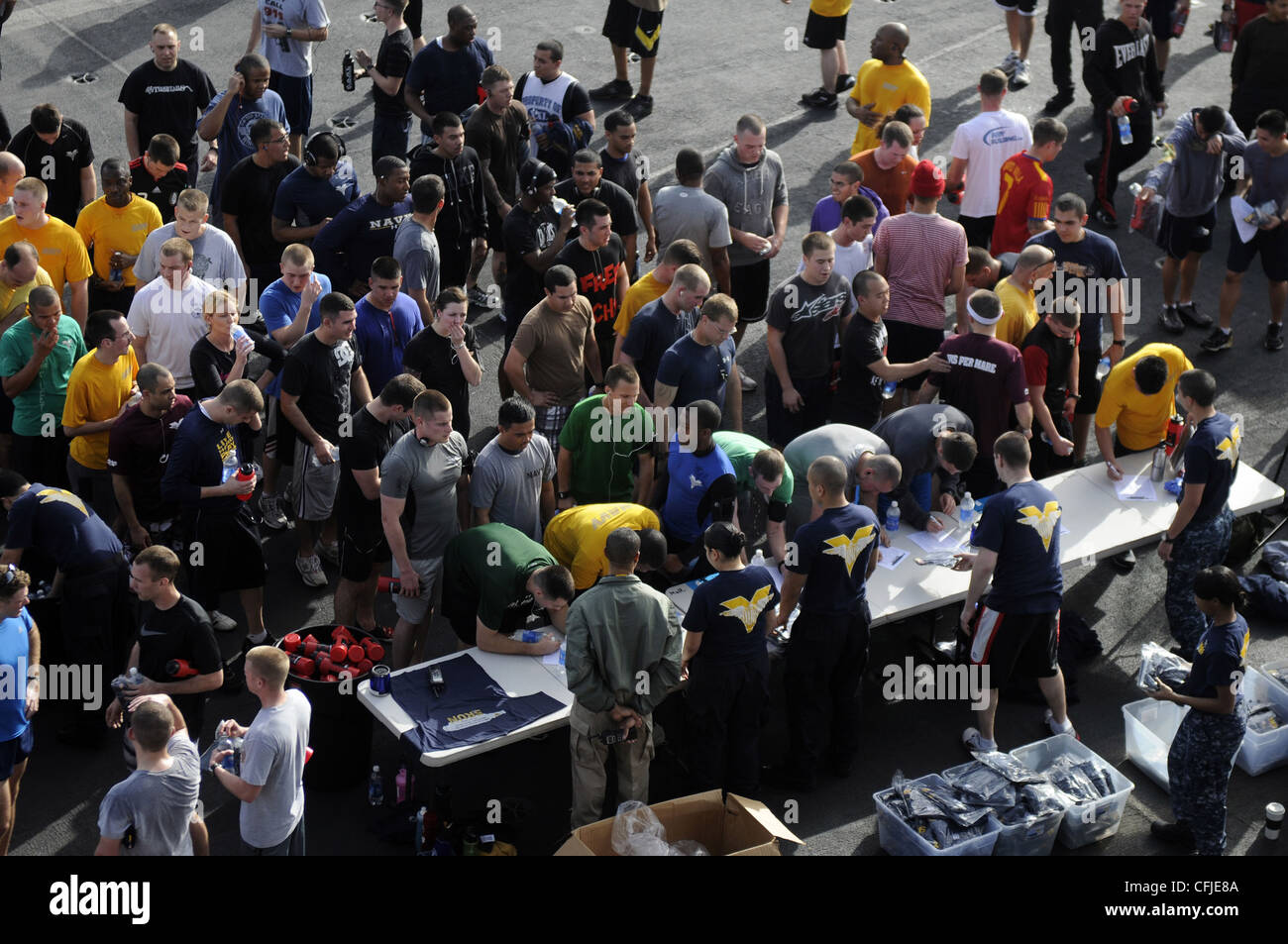 I marinai si iscrivono e raccolgono le loro T-shirt gratuite al tavolo morale, Welfare e Recreation dopo aver terminato una corsa di divertimento 5K sul ponte di volo della compagnia aerea di classe Nimitz USS Carl Vinson (CVN 70). Carl Vinson e Carrier Air Wing (CVW) 17 sono distribuiti nell'area di responsabilità della 5a flotta statunitense. Foto Stock